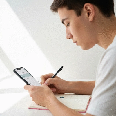 Person tracking daily habits on a smartphone or journal